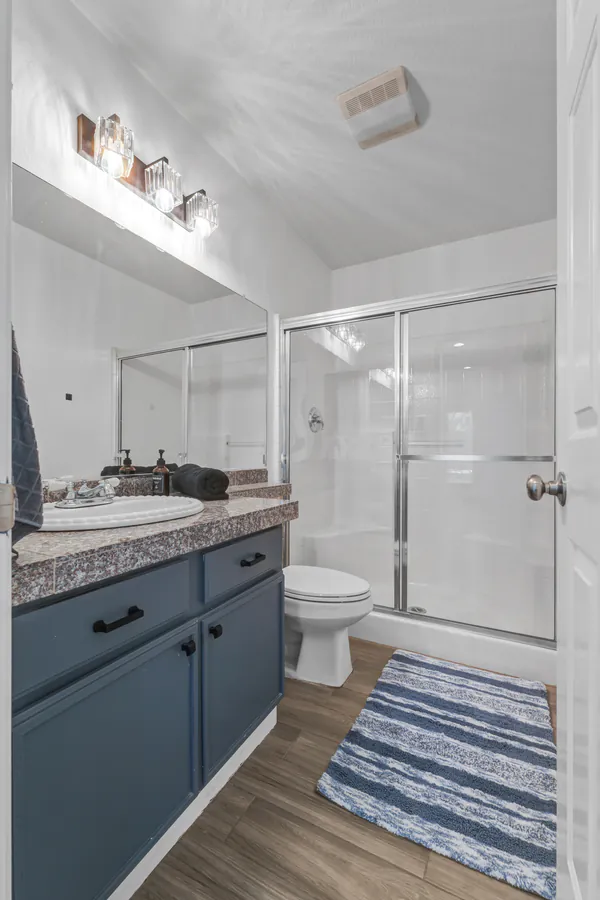 Bathroom with a navy vanity and a glass shower