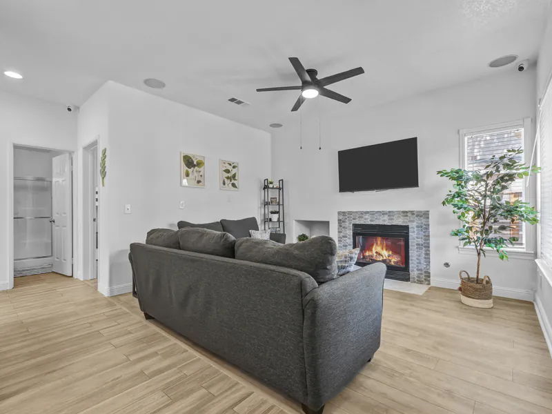 Family room with a gray sofa and a lit fireplace