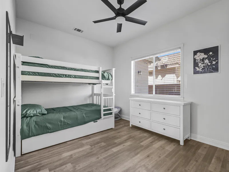 Bedroom with a white bunk bed, a trundle and a dresser